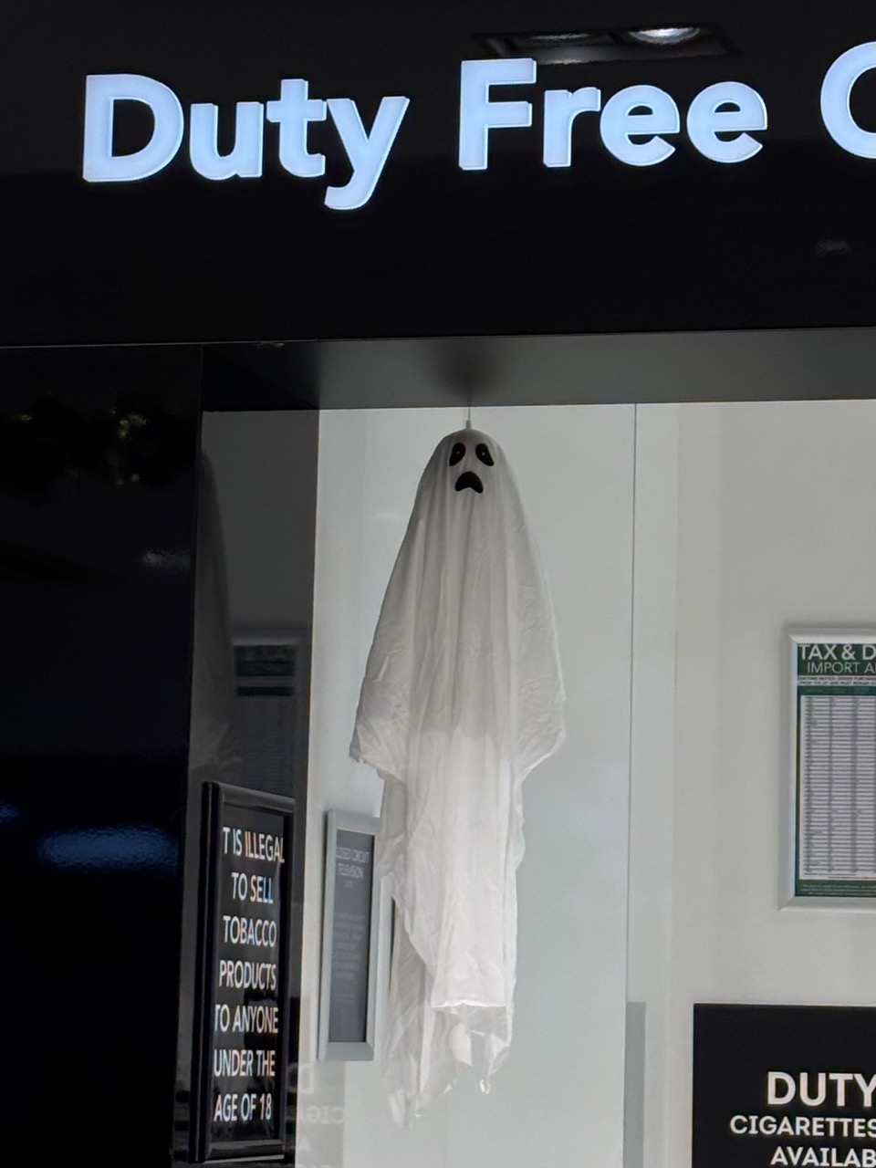A ghost decoration suspended below a sign for Duty Free